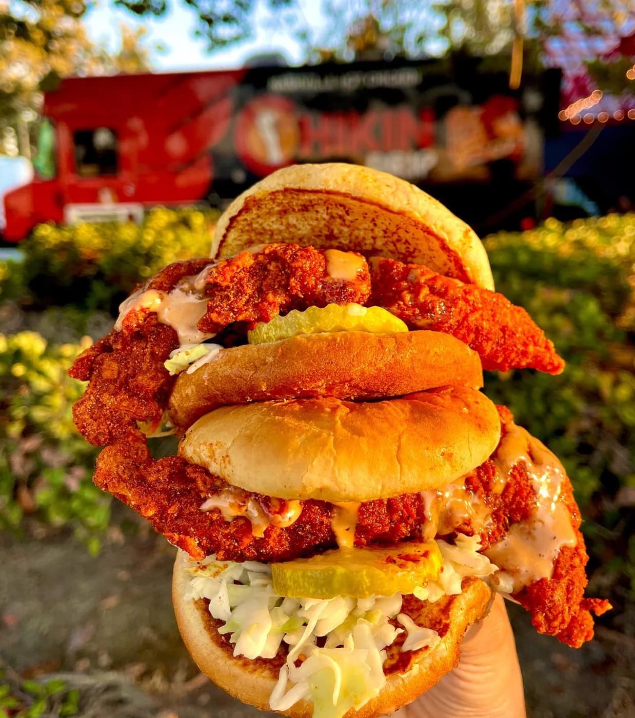 Two ChikinDrip chicken sliders with slaw, pickles and sauce